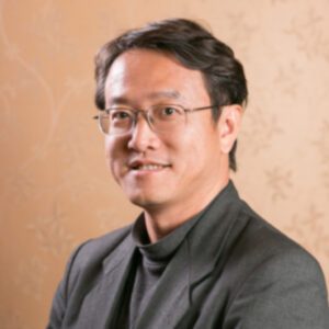 Asian man in glasses and wearing a black suit