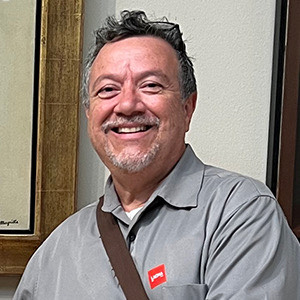 Smiling Latino man in a gray shirt